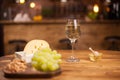 White wine glasss with white grapes and cheese on wooden table Royalty Free Stock Photo