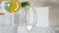 White wine is poured into glass on light background. Action. One glass of white wine in morning for single lady for Royalty Free Stock Photo