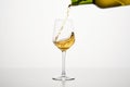White wine pouring from green bottle, close up shot on white isolated background. Royalty Free Stock Photo