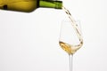 White wine pouring from green bottle on white isolated. Royalty Free Stock Photo