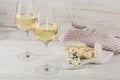 White wine served with cheese plate on light background. Two wineglasses of vino verde. Royalty Free Stock Photo