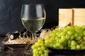 White wineglass and white yellow green bunches of berry grapes with bottle