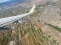 White wing from airplane window over city. Great views of landscape. Aerial view city life through a plane window. Wing of Royalty Free Stock Photo