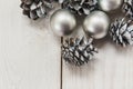 White winter cones on the wooden table with silver balls.Christmas composition