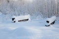 White winter forest during a snowfall. Landscape in a city park with a snow path, a bridge over a frozen river against the Royalty Free Stock Photo