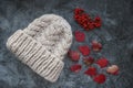 White winter handmade knitted hat with rowan berries and red autumn maple leaves on grey marble background, horizontal Royalty Free Stock Photo