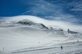 White winter mountains covered with snow in blue cloudy sky. Mountain skiers ride the slope. Alps. Austria. Pitztaler Gletscher Royalty Free Stock Photo