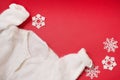 White winter sweater on red background with snowflakes. christmas card with warm clothes Royalty Free Stock Photo