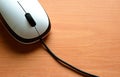 White Wired Computer Mouse on a Wooden Table