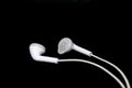 White wired earphones on black background. Royalty Free Stock Photo