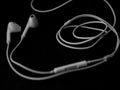 White wired headphones earbuds, headset on black background. Royalty Free Stock Photo
