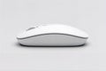 White wireless computer mouse on clean minimalist white surface. Royalty Free Stock Photo