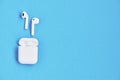 White wireless earphones on blue background