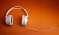 White wireless headphone on orange background Royalty Free Stock Photo