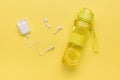 White wireless headphones and a bottle with a refreshing drink on a yellow background Royalty Free Stock Photo