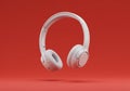 White wireless headphones on red background audio listening equipment Royalty Free Stock Photo