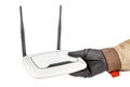 White wireless wi-fi router with two black antennas in electrician hand in protective glove and uniform isolated on white