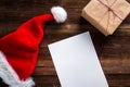 White Wishlist for Santa Claus laid on a wooden table