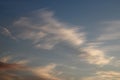 White wispy cirrus clouds pink tinged clouds below