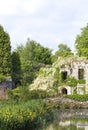 White wisteria on ruins, by a lake, in landscaped garden