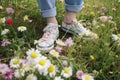 woman white sneakers grass green fashion flowers spring female lifestyle concept. Generative AI. Royalty Free Stock Photo