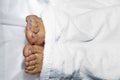 The white woman s bare feet, covered with a white towel, lie on the couch, peeking out from under the blanket. concept of a corpse Royalty Free Stock Photo