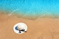 White woman straw hat laying on tropical sand beach with blue vibrant ocean water in background on sunny summer day. Vacations and Royalty Free Stock Photo