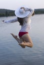 White woman in sun hat jump in water Royalty Free Stock Photo