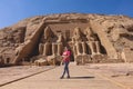 White Woman Tourist in front of the Colossal Statues of Ramesses II seated on throne near the entrance to Great Temple Abu Simbel Royalty Free Stock Photo
