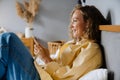 White woman using cellphone with earphones lying in bed at home Royalty Free Stock Photo