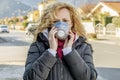 White woman walks the street with the protective mask in the times of the coronavirus `Covid - 19` which is affecting many people