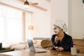 White woman wrapped towel applying face mask while looking in mirror Royalty Free Stock Photo