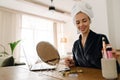 White woman wrapped towel doing makeup while looking in mirror Royalty Free Stock Photo