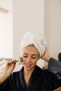 White woman wrapped towel massaging face with jade roller Royalty Free Stock Photo