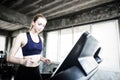 White women are exercising on exercise machines. Young people running on treadmill in gym. Young caucasian exercising on a Royalty Free Stock Photo