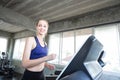 White women are exercising on exercise machines. Young people running on treadmill in gym. Young caucasian exercising on a Royalty Free Stock Photo