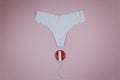 White women`s panties with a red signal and a hygienic tampon