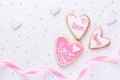 White wood backdrop for St Valentine day with Heart shaped cookies with word love and pink ribbon