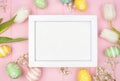 White wood frame with Easter eggs and spring tulip flowers against a pink wood background Royalty Free Stock Photo