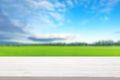 white wood table top on blur green field and blue sky with clouds background Royalty Free Stock Photo