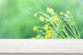 White wood table top on blur yellow wildflowers and foliage background Royalty Free Stock Photo