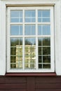 White wooden antique window on a wooden building. Old well-kept wooden house. Old Church and Windows with a cross Royalty Free Stock Photo