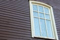 White wooden antique window on a wooden building. Old well-kept wooden house. Old Church and Windows with a cross Royalty Free Stock Photo