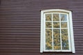 White wooden antique window on a wooden building. Old well-kept wooden house. Old Church and Windows with a cross Royalty Free Stock Photo