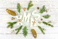 White wooden background with white christmas text and natural rustic decoration with christmas lights bokeh Royalty Free Stock Photo