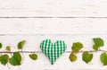 Green fresh grapevine border and heart on rustic white wood table background