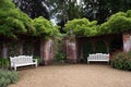 White wooden benches or seats in a walled garden