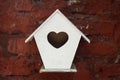 White wooden birdhouse on red brick wall Royalty Free Stock Photo