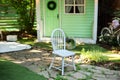 White wooden chair. Cozy terrace in garden with wooden chair. Decor in summer patio for relax. Autumn front porch home. Exterior w Royalty Free Stock Photo