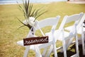 White wooden chair with rustic Reserved sign on green lawn . Outdoor wedding ceremony Royalty Free Stock Photo